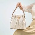 anj-pattern-embroidered-leather-convertible-backpack-tote-model-sitting-knee-handheld